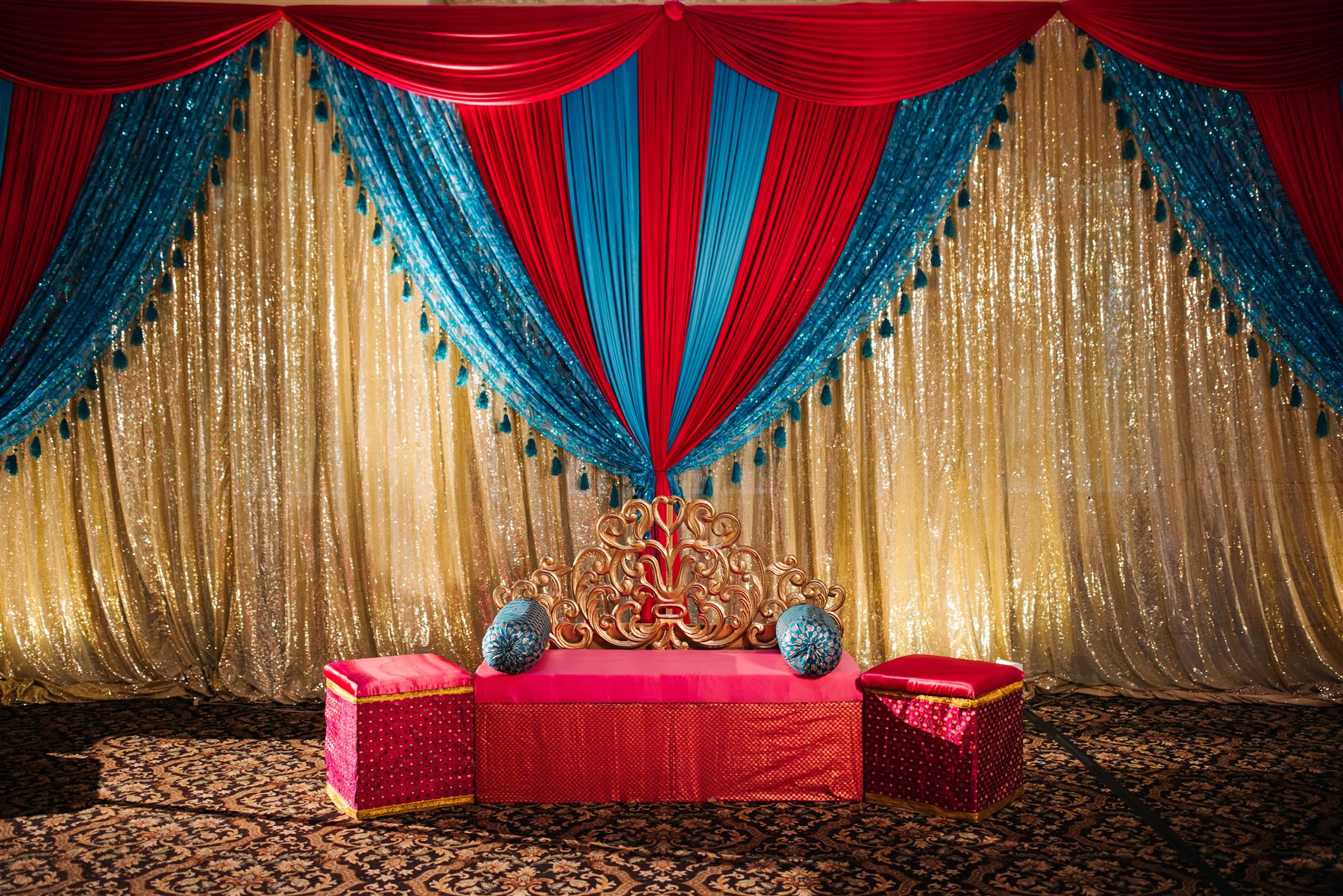The sangeet stage in red, blue, and gold