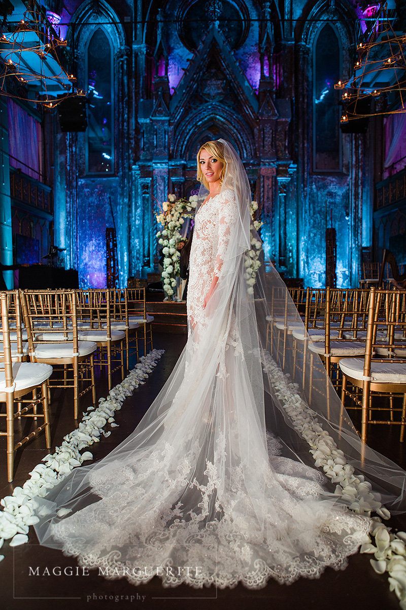The bride beneath the altar arches, train cascading