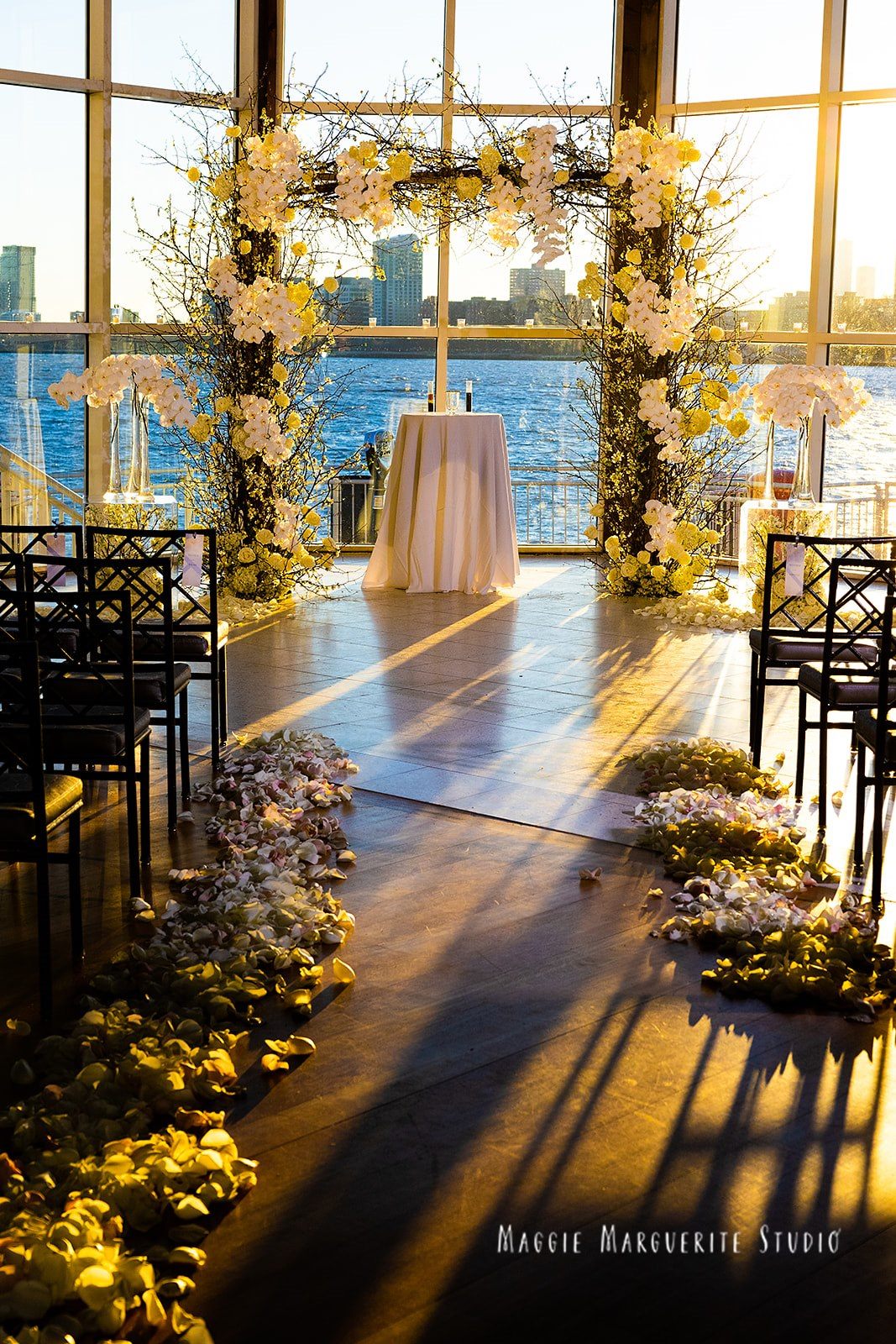 Golden hour down the petal-lined aisle, orchid arch against the Hudson